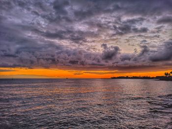 Scenic view of sea against dramatic sky during sunset