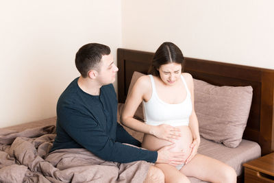 Young couple sitting on bed