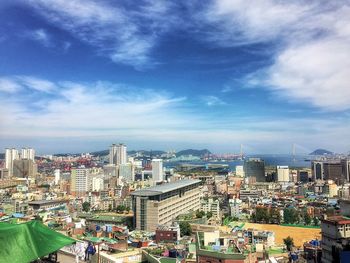 Aerial view of city against cloudy sky