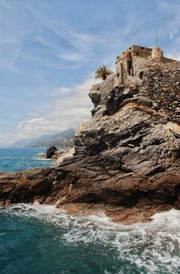 Low angle view of rock formation in sea against sky