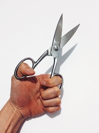 Close-up of hand holding over white background