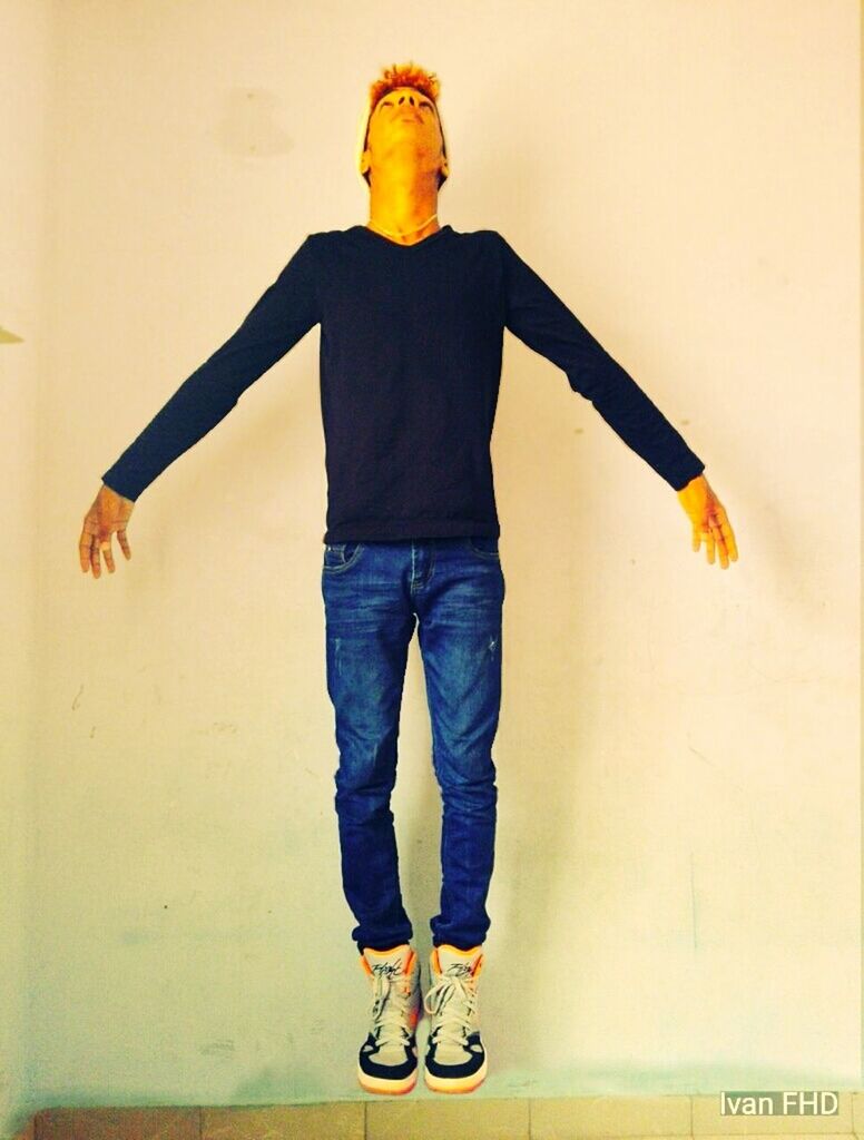 FULL LENGTH OF A MAN JUMPING IN YELLOW