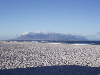 Scenic view of sea and mountains against blue sky