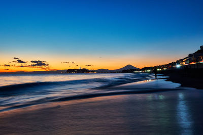 Scenic view of sea against clear sky at sunset