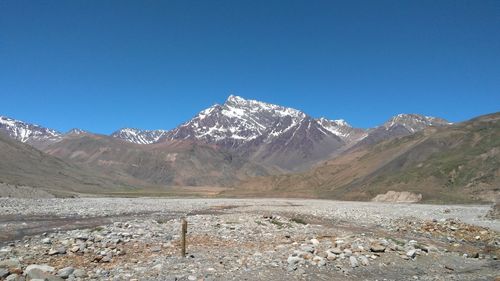 Scenic view of snowcapped mountains against clear blue sky