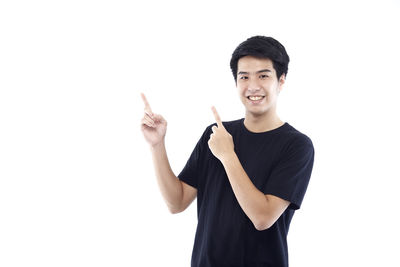 Portrait of young man standing against white background