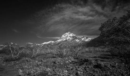 Scenic view of land and mountains against sky
