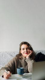 Portrait of young woman using laptop on table