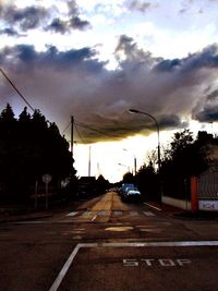 Road against cloudy sky at sunset