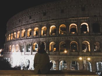 Woman sitting in front of coliseum