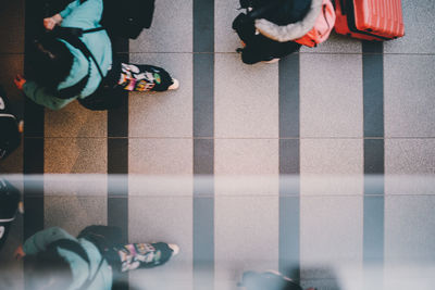 Low section of people standing on tiled floor