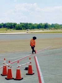 Ground crew member standing on airport runway 