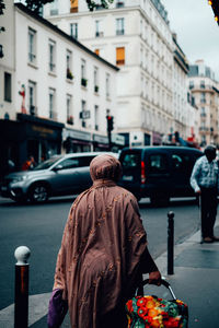 Rear view of man walking on street in city