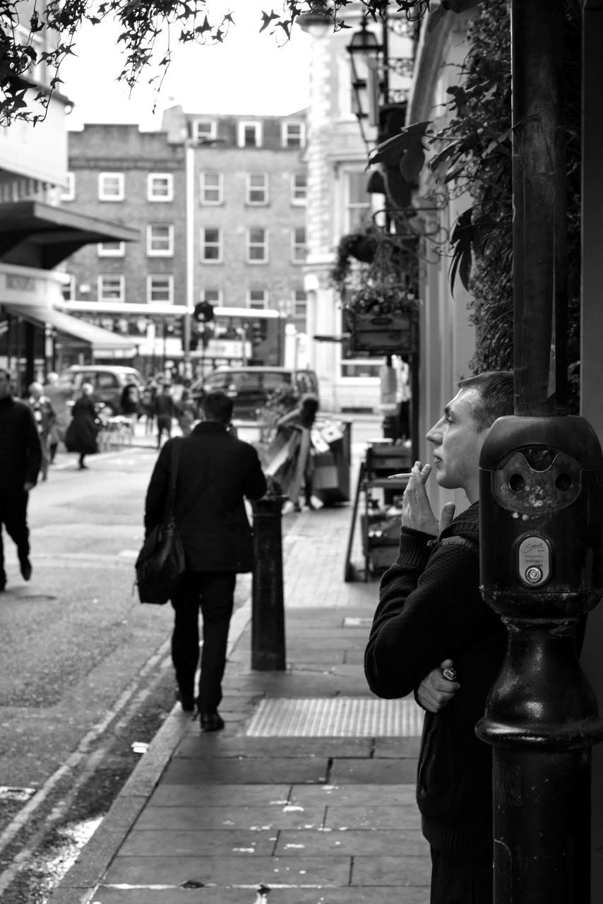 building exterior, city, architecture, street, men, built structure, lifestyles, walking, rear view, city life, person, incidental people, casual clothing, full length, leisure activity, tree, city street, car