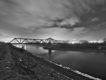 Bridge over river against sky at night