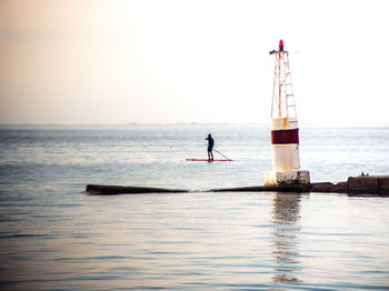 Man standing in sea against clear sky