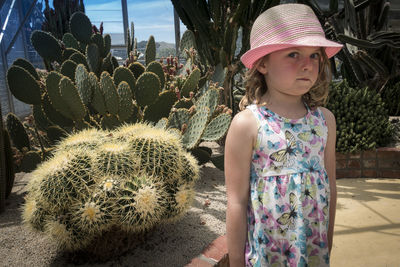 Portrait of girl standing by cactus plants