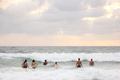 People at beach against sky