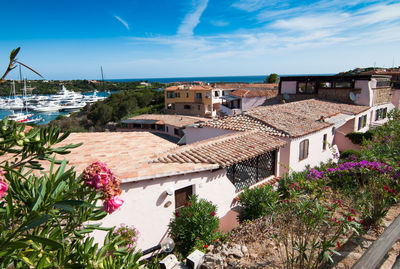 Houses by swimming pool in city against sky