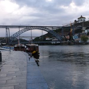 Bridge over river in city against sky