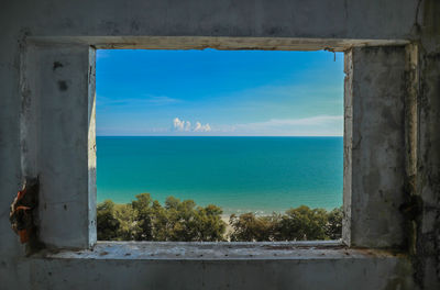 Scenic view of sea against sky seen through window