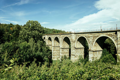 Low angle view of arch bridge against sky