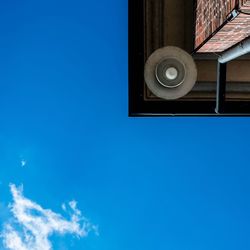 Low angle view of window against blue sky