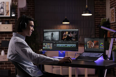 Side view of man using laptop at office