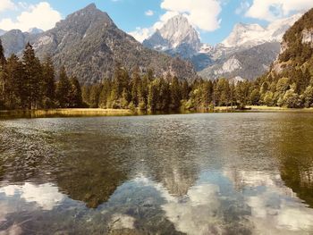 Scenic view of lake by mountains against sky