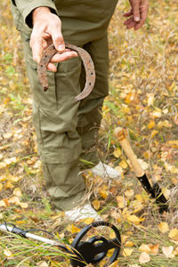 Man with electronic metal detector device working on outdoors.