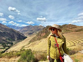 Full length of woman standing on mountain against sky