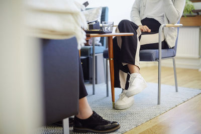 Low section of therapist and patient sitting at workshop during session