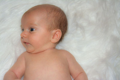 Portrait of cute baby girl on bed at home