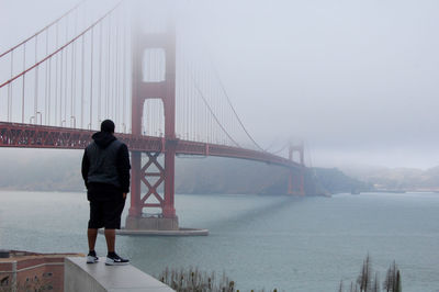 Person standing on bridge over river