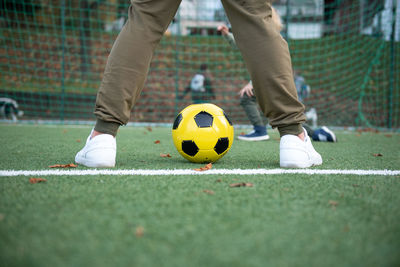 A little boy plays soccer with his father on the soccer field