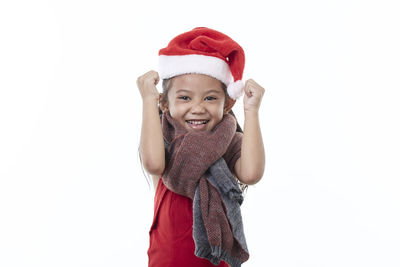 Portrait of smiling girl standing against white background