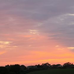 Scenic view of silhouette field against sky during sunset