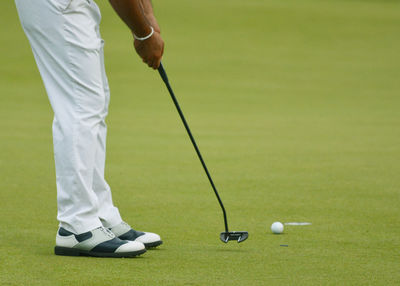 Low section of woman standing on golf ball