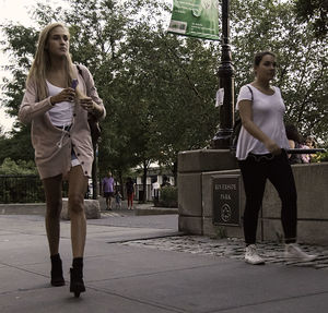 Full length of woman standing on tree trunk