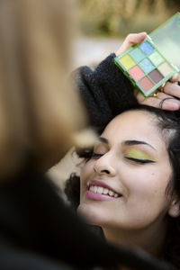 Young woman having her make-up done
