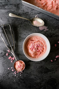 High angle view of ice cream in bowl by spoon on table