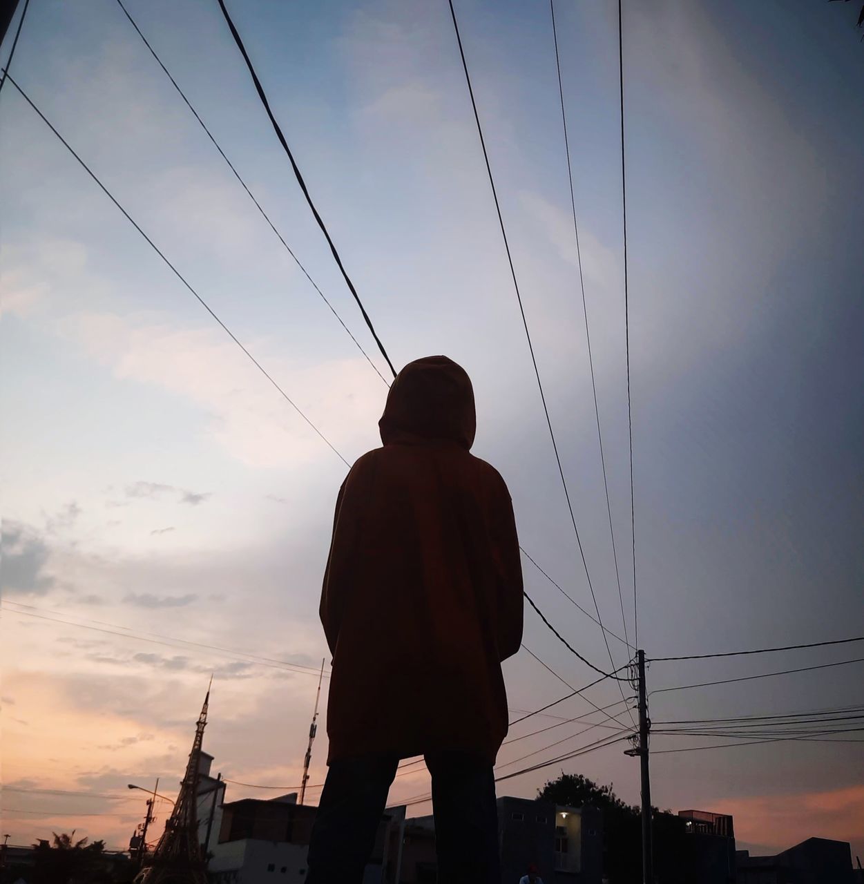 sky, silhouette, cable, sunset, architecture, evening, electricity, cloud, nature, one person, city, rear view, men, dusk, adult, technology, built structure, standing, power line, low angle view, outdoors, lifestyles, building exterior, transportation, power supply, electricity pylon, backlighting, person