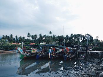 Boats moored on shore against sky