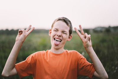 Portrait of a funny boy shows two fingers, victory or peace.