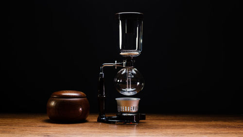 Close-up of wineglass on table against black background