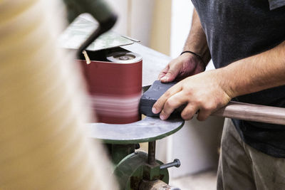 Close up on hands finishing an restored axe