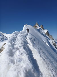 Low angle view of snowcapped mountain against clear sky