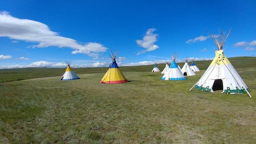 Traditional windmill on field against blue sky