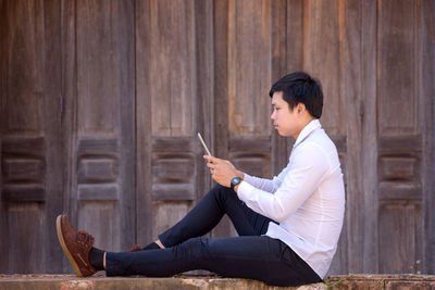 Side view of man using mobile phone