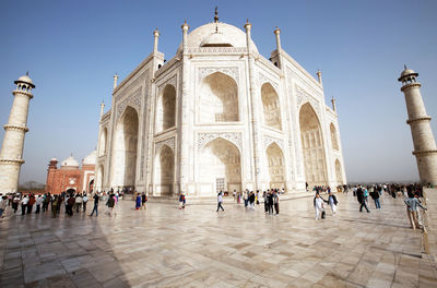 People visiting taj mahal against clear blue sky